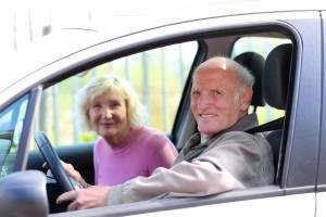 Happy senior couple driving modern car on their vacation trip